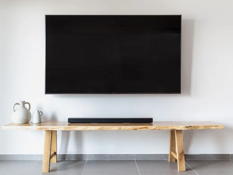 Televisão de tela plana instalada na parede da sala